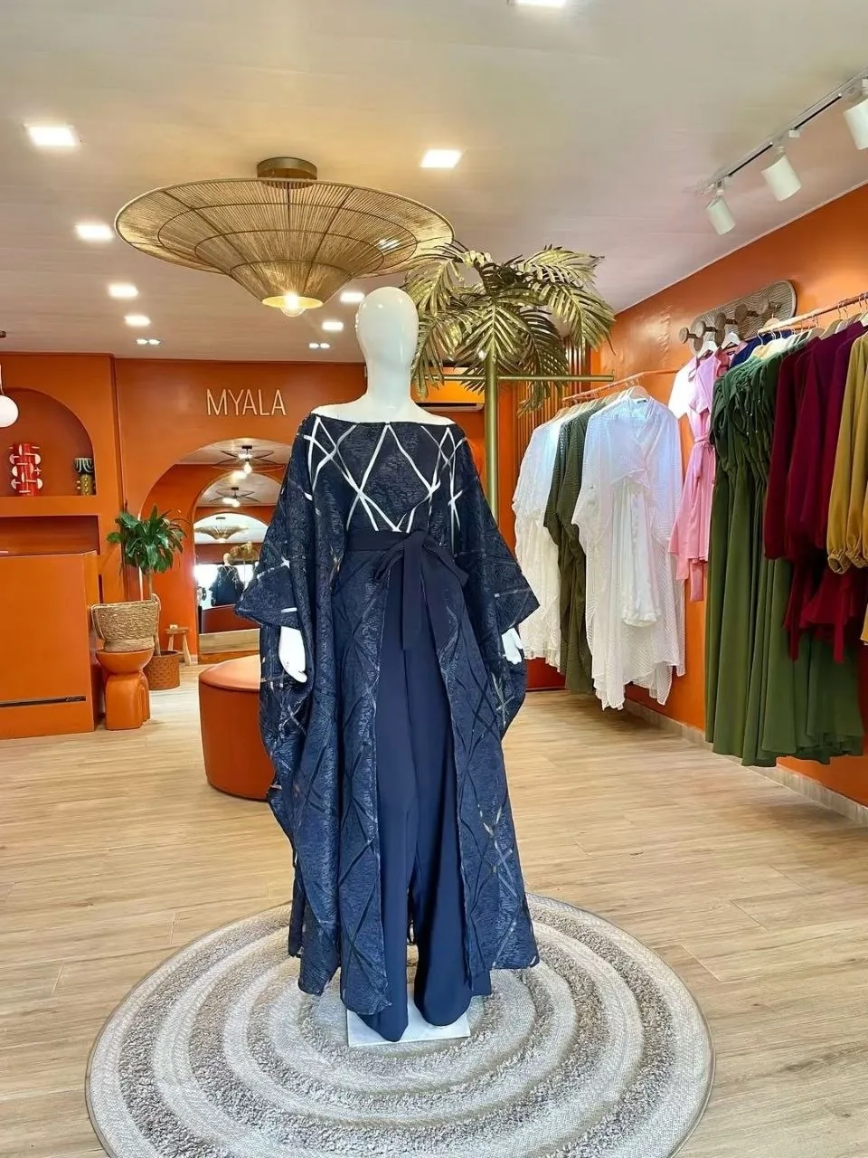 La boutique Myala : murs orange, enseigne MYALA, portants et vitrine